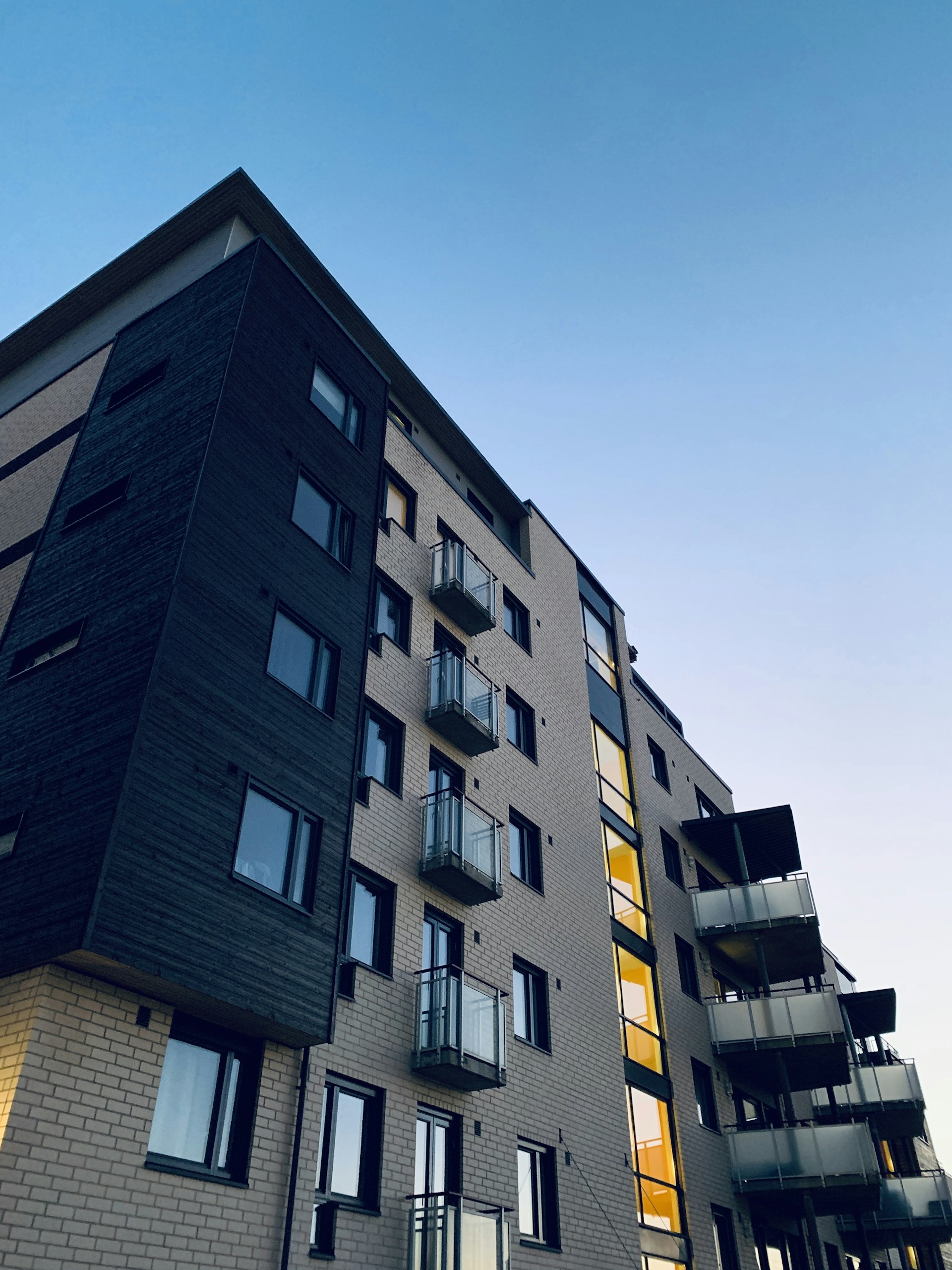 Modernes Wohnhaus mit warm beleuchtetem Treppenhaus in der Abenddämmerung