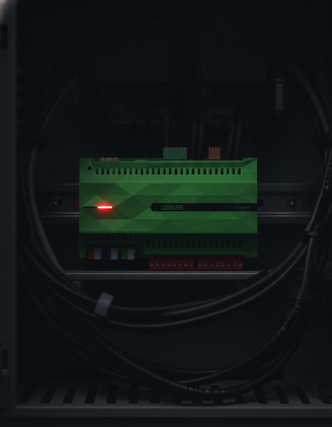 Loxone Miniserver im dunklen Schaltschrank, die Status-LED leuchtet rot